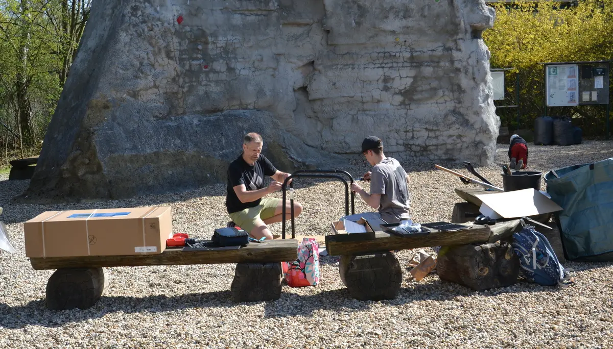 Zwei Personen bauen einen Grill zusammen. Im Hintergrund der Fuß des Braschelsteins. | © 	 Theodor Kubusch