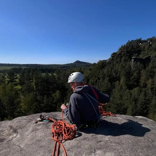 Kletterer auf einem Gipfel im Elbsandsteingebirge  bei gutem Wetter, mit rotem Seil in der Hand. | © Max Lübbers